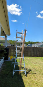 2m/70cm J-pole antenna attached to a 2x4 propped up with a ladder