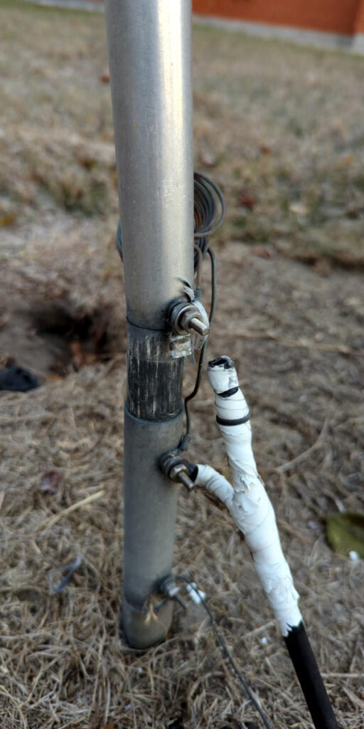 Broken feed line connection at the base of a ground mounted vertical antenna.